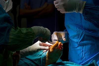 Foot and ankle specialist conducting a precise operation to treat a podiatric condition.