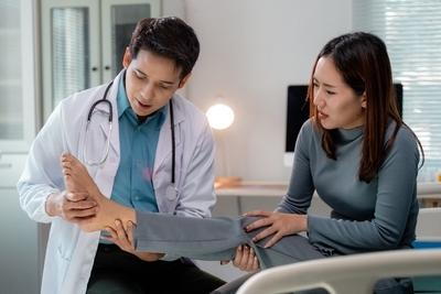 Podiatrist checking the foot condition of a female patient.