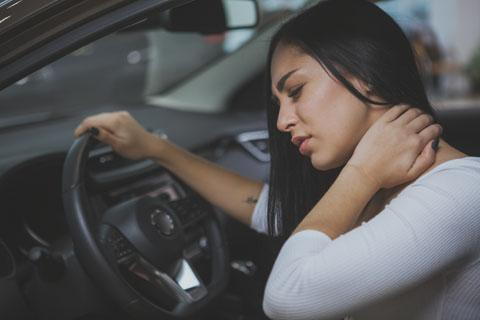 driving woman holding her neck