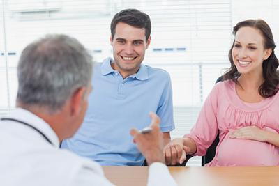 Pregnant-woman-and-husband-consult-with-the-doctor-in-clinic.