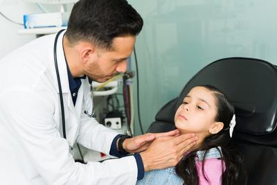 Doctor holding the throat for checking on clinic.