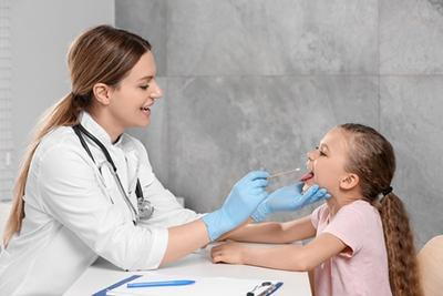 Child-Undergoing-Throat-Swab-Test-by-Pediatrician