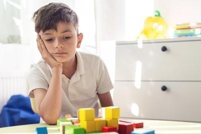 Kid looks confuse in puzzle on the table.