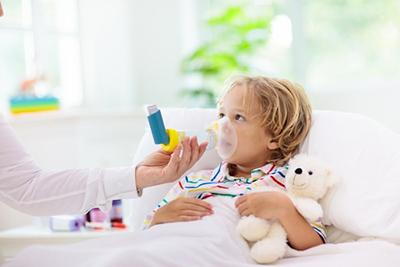 Pediatrician assisting toddler with asthma inhaler