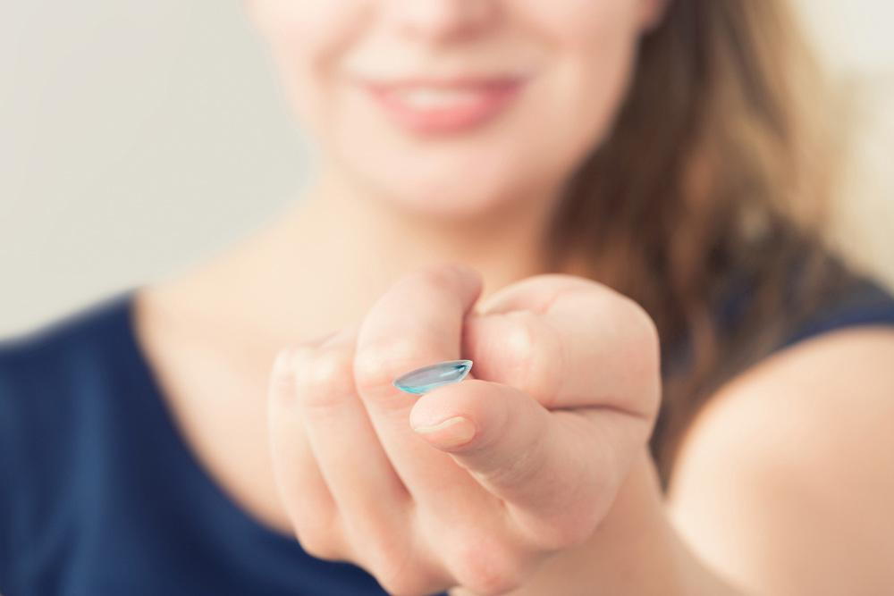 A woman holding contact lens