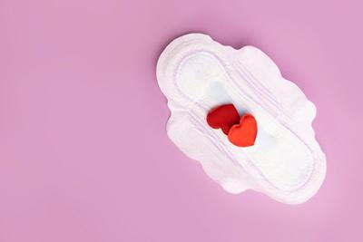 Sanitary pad with heart-shaped blood symbolizing perimenopausal spotting