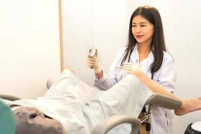 Female doctor conducting Pap smear screening test