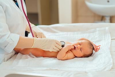 Doctor-use-stethoscope-in-baby-laying-down-on-clinical-bed.