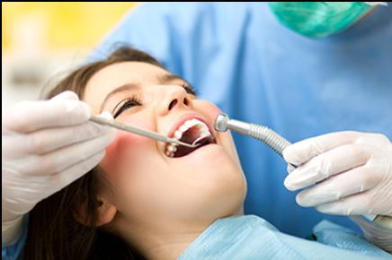 Sedation dentistry performed by dentist holding dental tools while treating happy patient