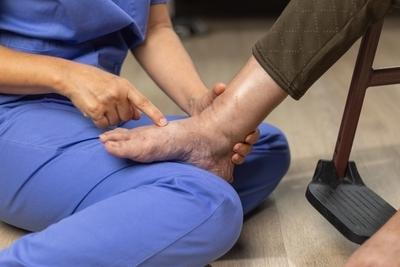 Doctor checking the foot of a senior patient