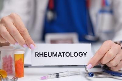 Doctors hand with Rheumatology label and medicines around.