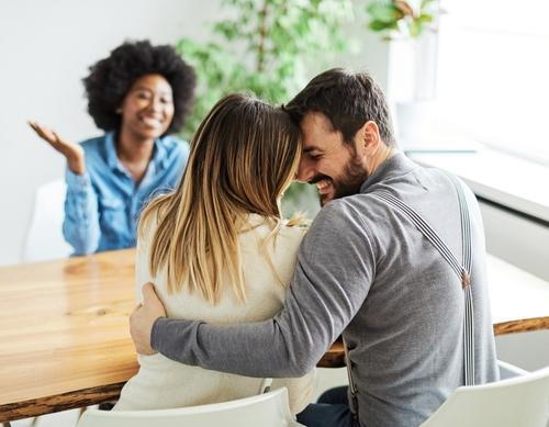 Happy married couple attending a counseling session with a therapist.