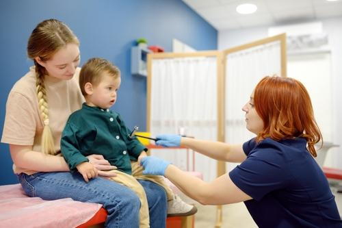 Child having reflexes tested by pediatrician