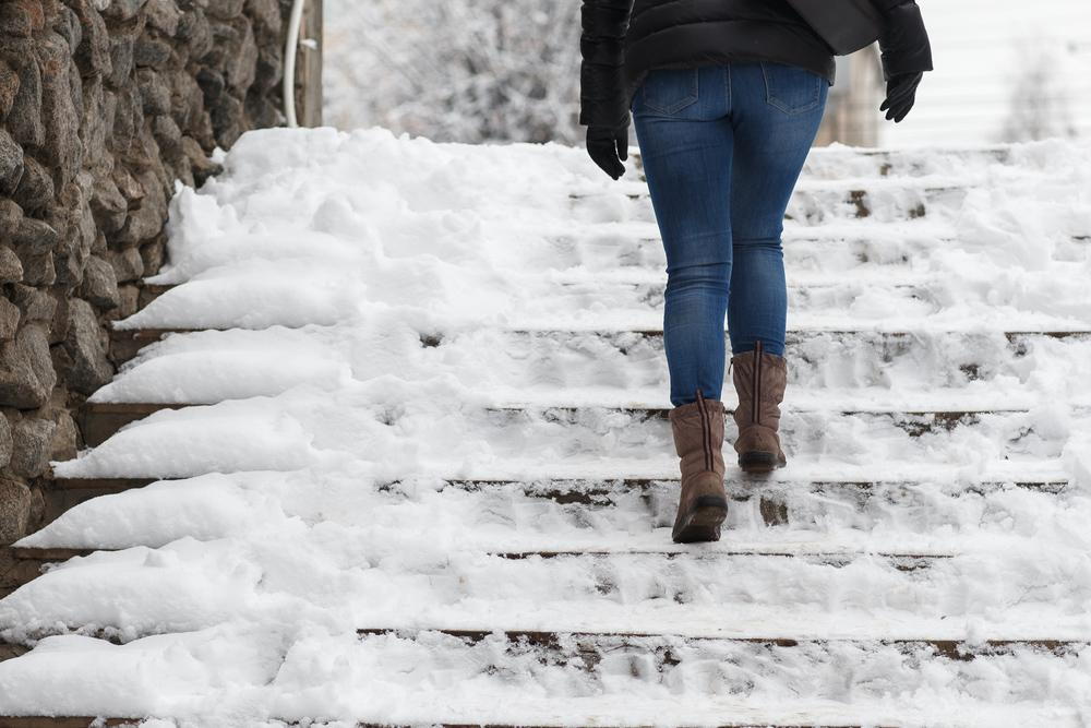 woman walking up some snowy stairs