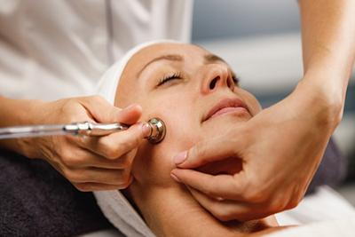 Close-up of woman undergoing cosmetic microdermabrasion treatment