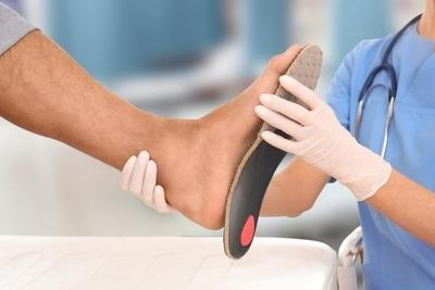 Doctor fit the foot orthotics in patient.