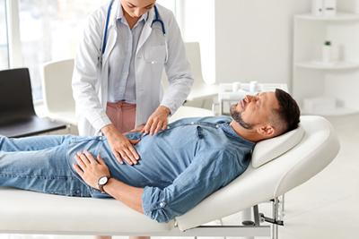 Doctor checking the abdomen of the patient on clinic