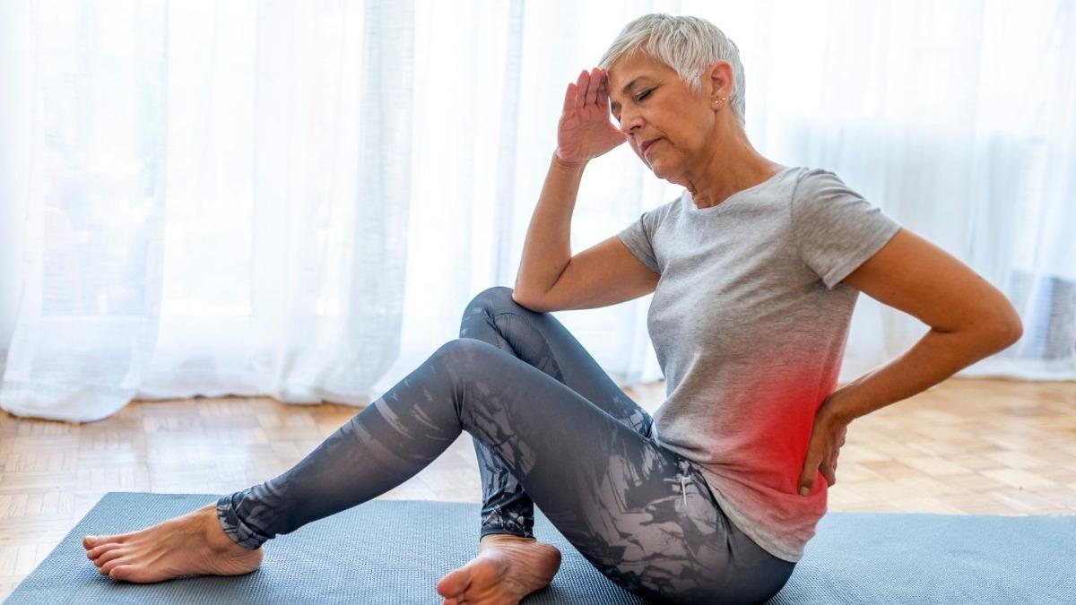 Woman With Back Pain While Sitting On A Mat