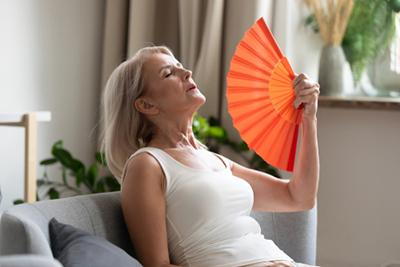 Woman in age feeling hot due to menopause condition