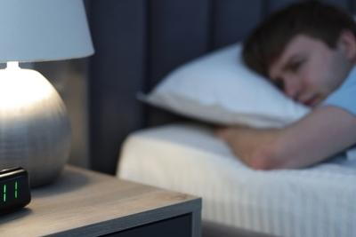 Young man suffering from Insomia on bed