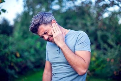 Man holding ear from allergy-related discomfort