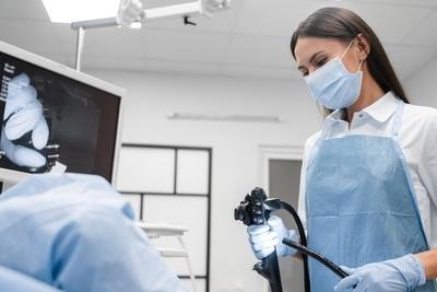 Doctor holding an colonoscope for patient examination.