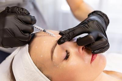 Botox facial injection given by dermatologist to female client