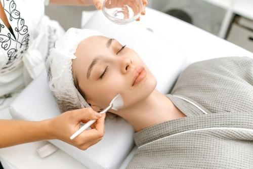 Woman receiving a chemical peel treatment at a skincare clinic