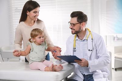 Doctor checking the young girl with her mother on clinic