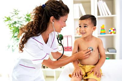 Doctor-smiling-while-checking-the-young-boy-heartbeat-in-clinic