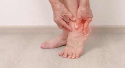 Person suffering from ankle pain in red highlights