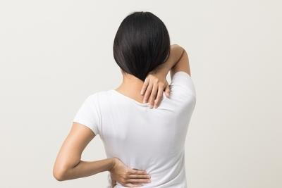 Woman in white shirt suffering in back and neck pain