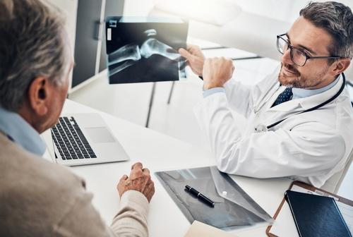 Pain management physician reviewing X-ray images of arthritis