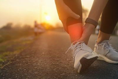 Runner suffering from foot fracture pain beside the road