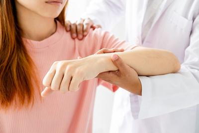 Woman-with-Repetitive-Strain-Injury-Consults-Osteopath