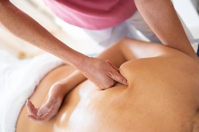 Therapist massaging and pressing the muscle of the patient.