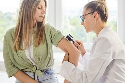 Woman on skin screening with the doctor on clinic