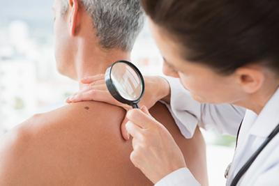 Doctor-magnifying-the-mole-of-patient-in-the-back
