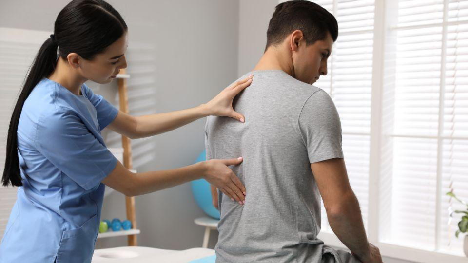 Physical Therapist Assessing A Patient's Back