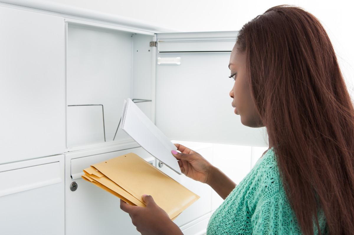 A woman retrieves her security deposit check from the mail