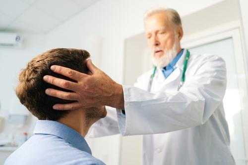 Male client receiving chiropractic care to relieve headache and tension