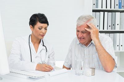 Doctor talking to a senio patient on clinic.