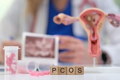 PCOS letters with pills and uterus model on the desk