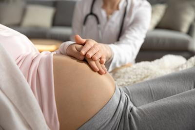 Doctor checking the pregnant woman tummy