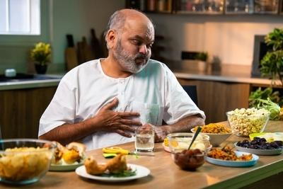 Man feeling tired and unwell after eating due to digestive problems