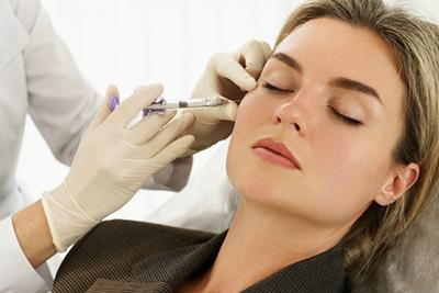 Woman in procedure of dermal fillers on face
