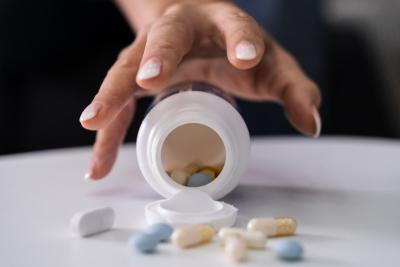 Addiction in medicine grabbing the tablets on table.