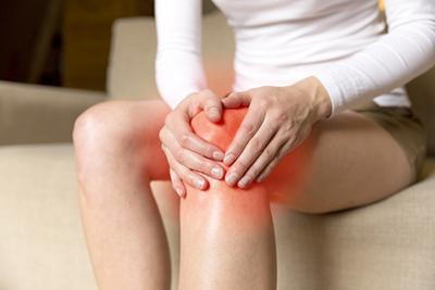 Woman-holding-her-knee-in-pain-with-red-highlights.