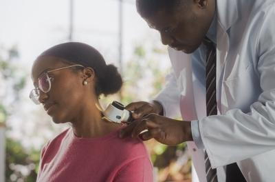 Doctor examining patient's skin for cancer signs