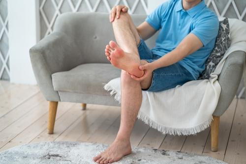 Man suffering from heel pain at home
